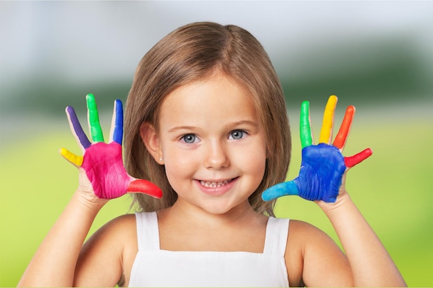 Bambina che mostra le mani dipinte su sfondo sfocato