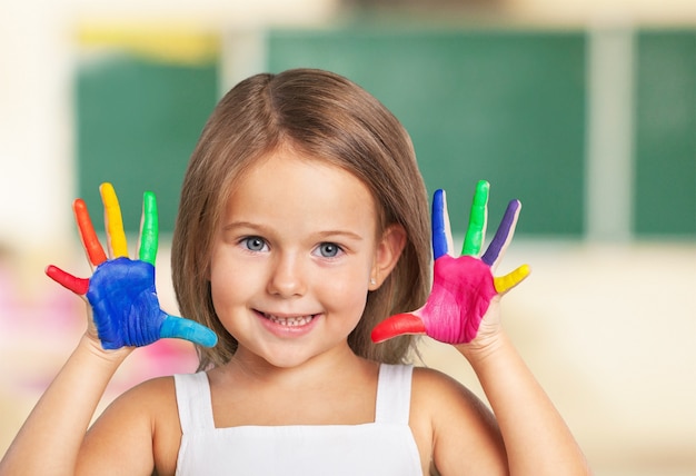 Bambina che mostra le mani dipinte sullo sfondo