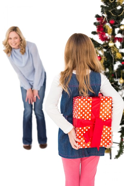 Bambina che nasconde il regalo di Natale dalla madre