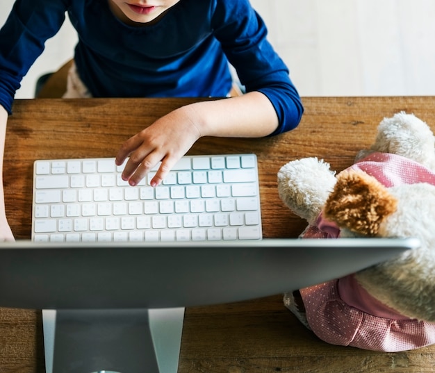 Bambina che per mezzo del concetto del computer