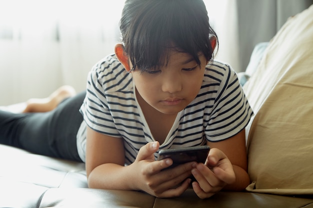 Bambina che per mezzo dello smartphone a casa