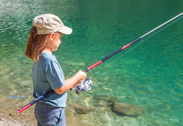 bambina che pesca in montagna