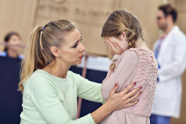 bambina che piange mentre con sua madre da un dottore in consultazione