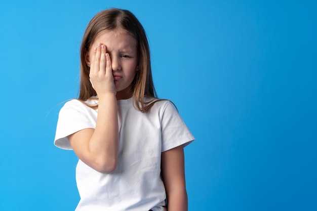 Bambina che piange su sfondo blu in studio