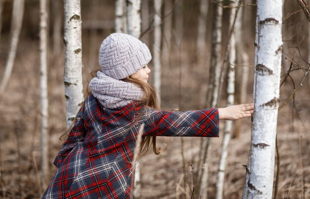 Bambina che posa nella foresta