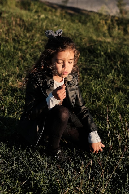 Bambina che raccoglie fiori nel campo da soffiare