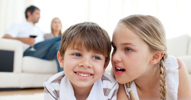 Bambina che racconta un segreto a suo fratello