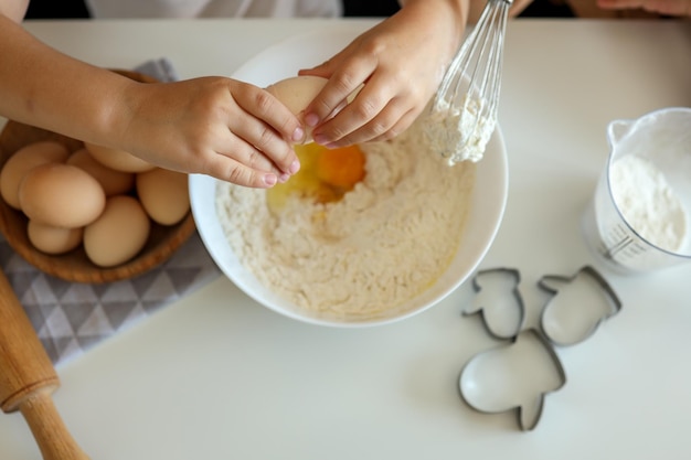 Bambina che rompe un master class di cucina del primo piano dell'uovo