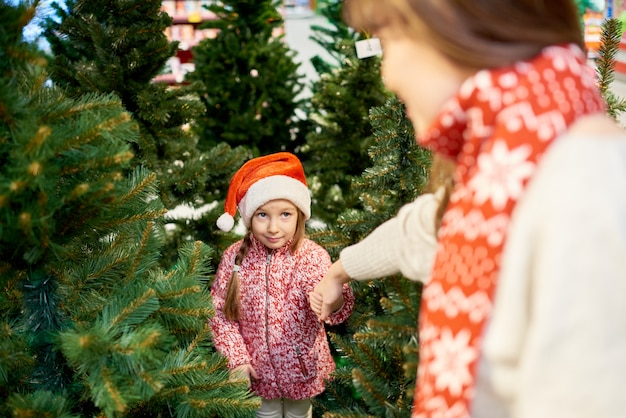 Bambina che sceglie l'albero di Natale