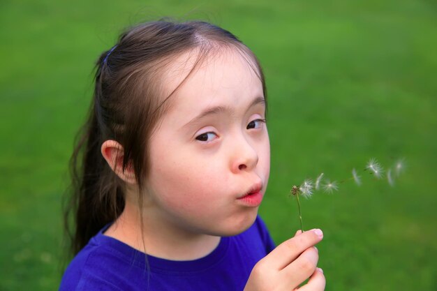 Bambina che soffia il dente di leone