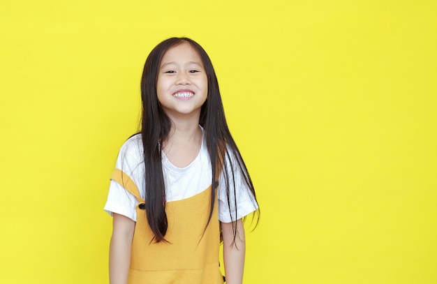 Bambina che sorride sul fondo giallo