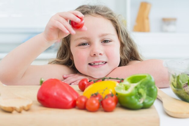 Bambina che sostiene pomodoro ciliegia