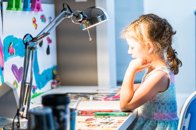 Bambina che studia a casa durante la scuola di e-learning.