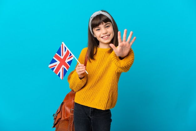 Bambina che studia inglese isolato su sfondo blu, contando cinque con le dita