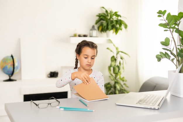 Bambina che studia online usando il suo laptop a casa