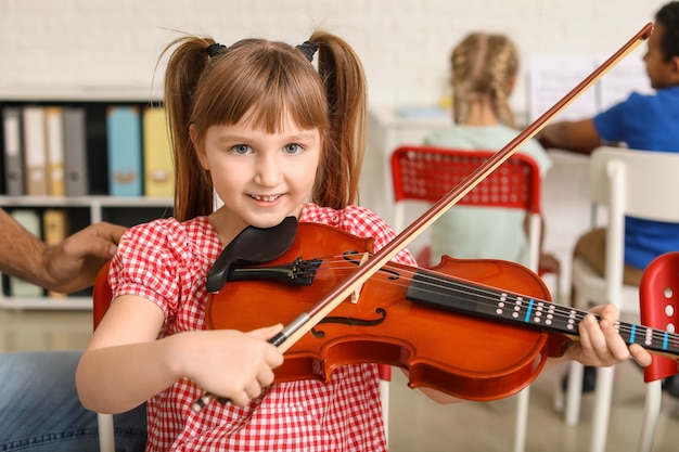 Bambina che suona il violino alla scuola di musica