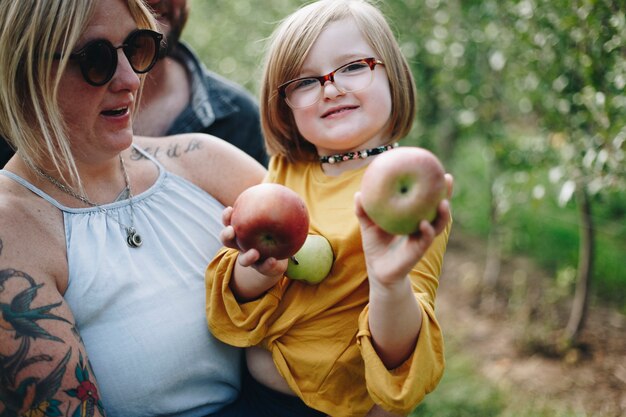 Bambina che tiene alcune mele