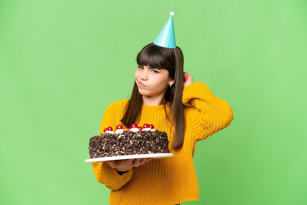 Bambina che tiene la torta di compleanno su sfondo chroma key isolato con dubbi