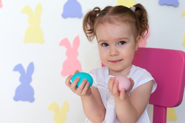 Bambina che tiene sorridere delle uova di Pasqua.