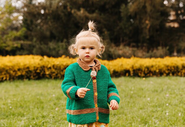 Bambina che tiene un dente di leone nelle sue mani.