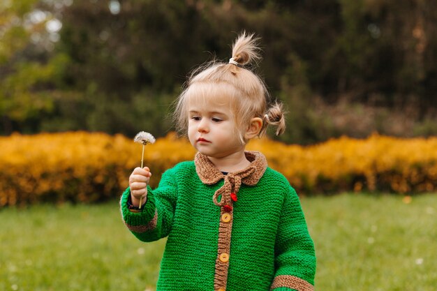 Bambina che tiene un dente di leone nelle sue mani.