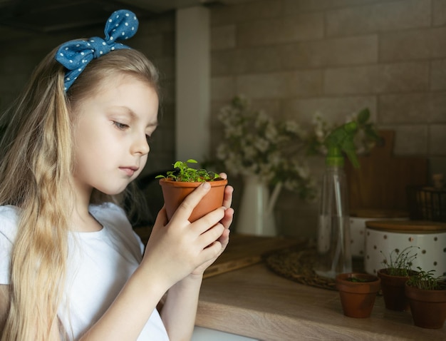 Bambina che tiene un vaso di piantine