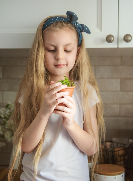 Bambina che tiene un vaso di piantine