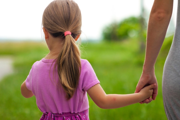 Bambina che tiene una mano di sua madre