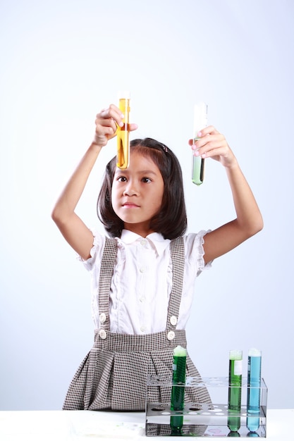 Bambina che tiene una provetta con liquido, chimica di scienziato e cono di educazione scientifica