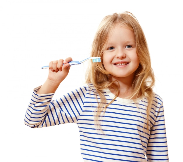 Bambina che tiene uno spazzolino da denti.