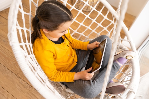 Bambina che utilizza il computer tablet a casa.