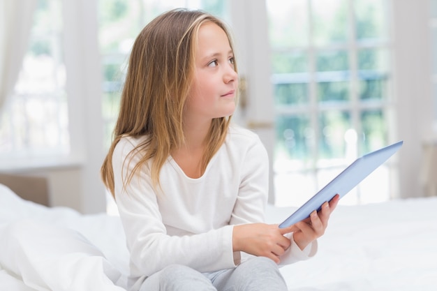 Bambina che utilizza il pc del ridurre in pani che si siede sulla sua base