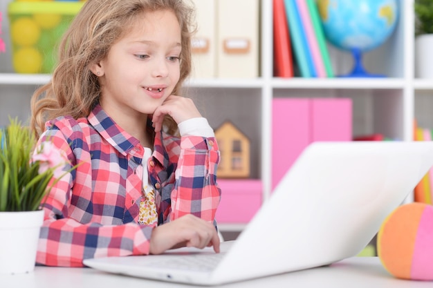 Bambina che utilizza un computer portatile moderno