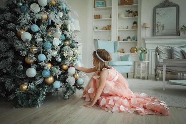 Bambina con albero di Natale a casa