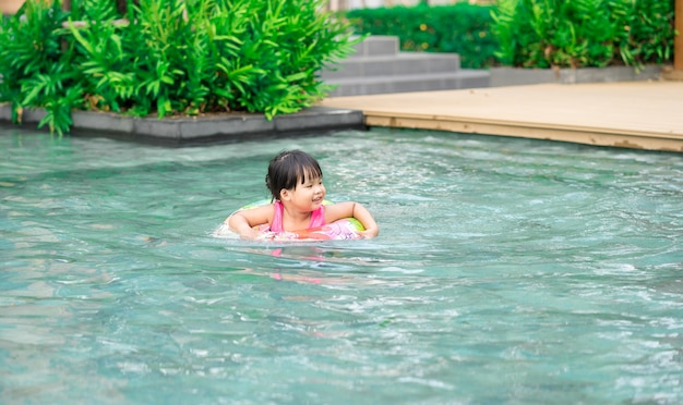 Bambina con anello di gomma in piscina