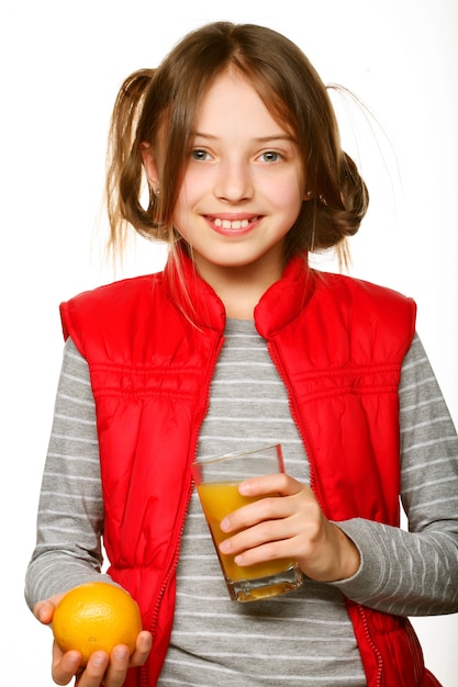 Bambina con arance e succo. Isolato su bianco.