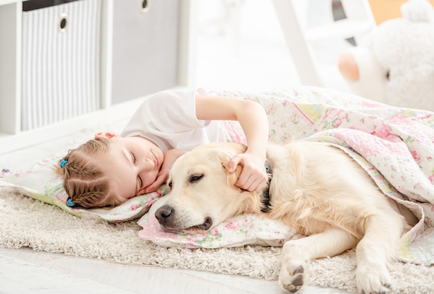 Bambina con cane sotto coperta