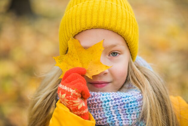 Bambina con capelli biondi nella sosta di autunno