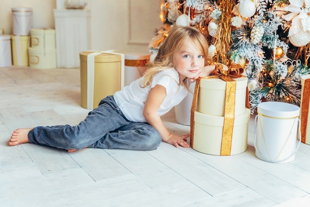 Bambina con confezione regalo vicino all'albero di Natale