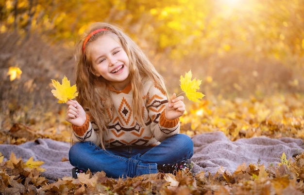 Bambina con foglie gialle