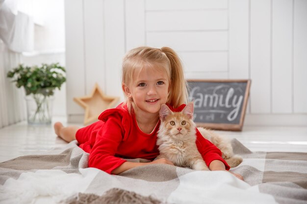 bambina con gattino sdraiato sul pavimento della casa concetto di famiglia umana e un animale domestico