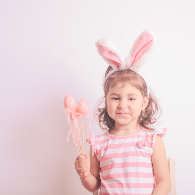 Bambina con gli ovetti rosa per la caccia di Pasqua