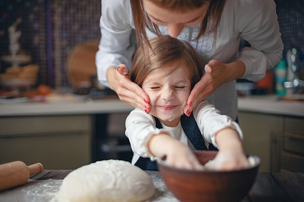 Bambina con i capelli corti impastare in cucina