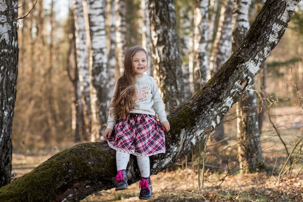 bambina con i capelli lunghi, seduto nella foresta