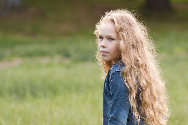 Bambina con i capelli ricci sensazione di tristezza - ritratto all'aperto, ritratto