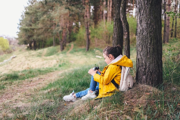 Bambina con il binocolo in una bella radura della foresta