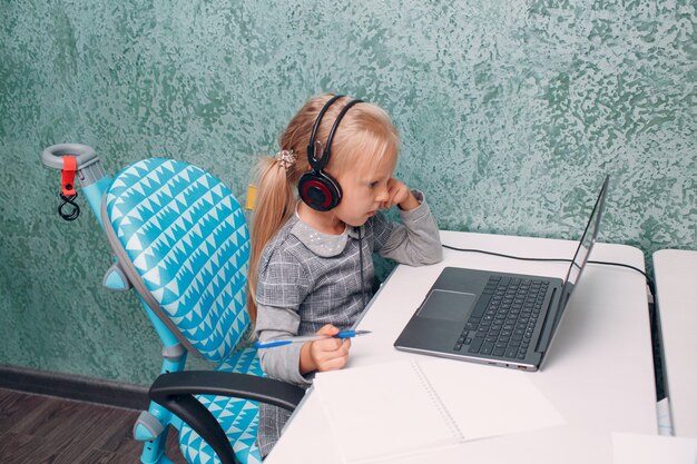 Bambina con il computer portatile che impara e si prepara al ritorno a scuola