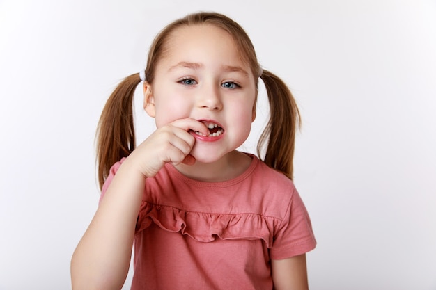 Bambina con il primo dente da latte oscillante