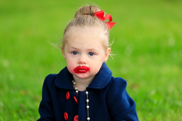 Bambina con il viso macchiato di rossetto