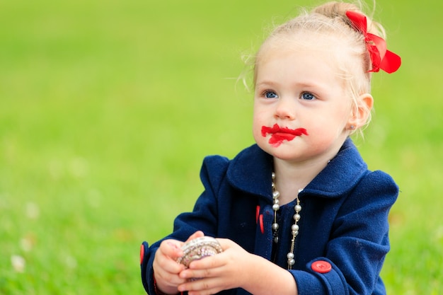 Bambina con il viso macchiato di rossetto